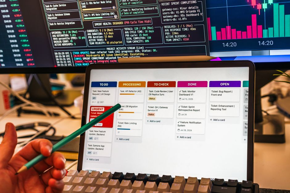 Monkey app dashboard on laptop and phone, team reviewing daily stand‑up in an office
